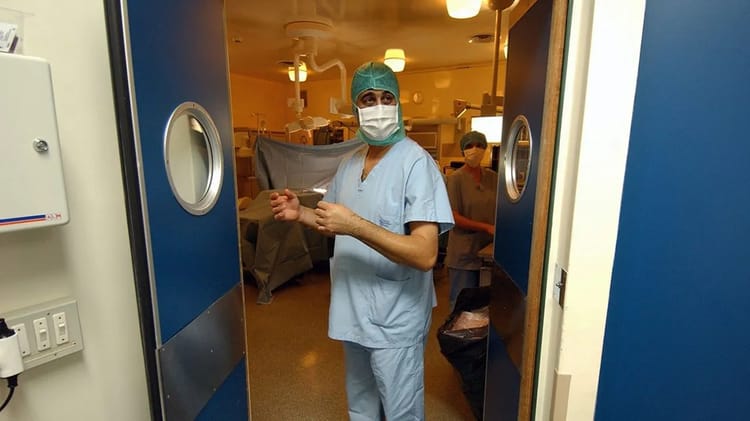 Médecin en uniforme avec masque dans un hôpital français.