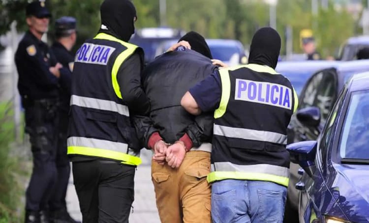 Policiers arrêtant un homme lors d'une opération en plein air.