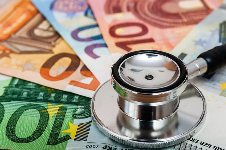 Stéthoscope sur des billets d'euros, illustration des coûts de santé.