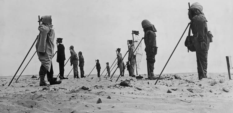 Soldats observant un test nucléaire dans le désert.
