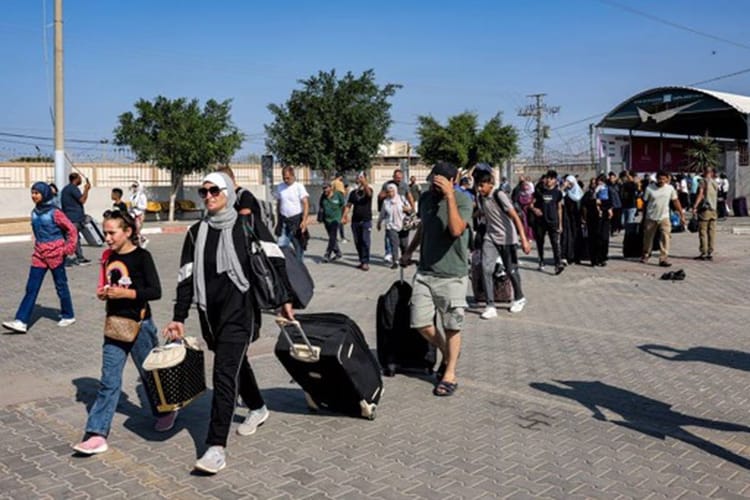 Gaza : 500 étrangers et binationaux évacués vers... Civils évacuant Gaza avec bagages dans un centre d'accueil.