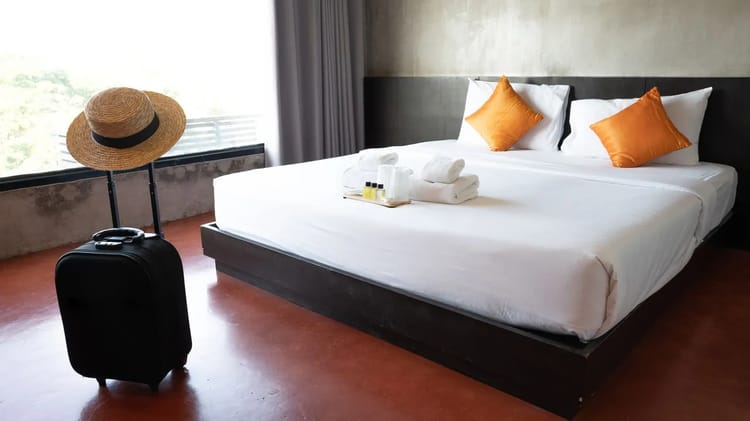 Chambre d'hôtel élégante avec lit double et vue sur l'extérieur.