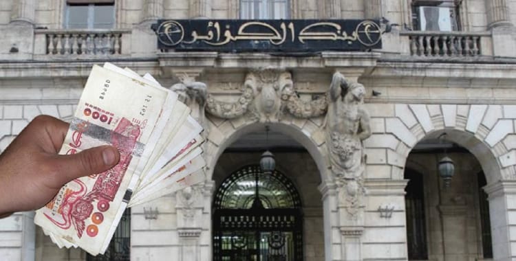 La Banque d'Algérie prévoit de lancer une nouvelle pièce de 10 dinars en acier inoxydable Main tenant des billets de banque devant la Banque d'Algérie.