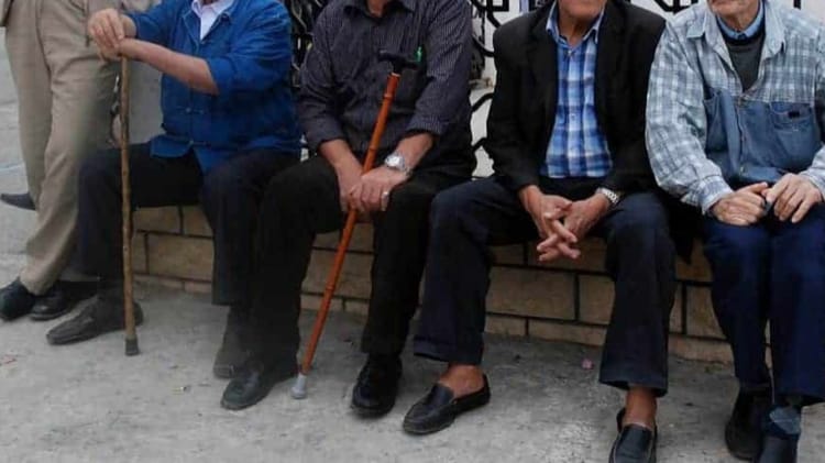 Groupe de seniors assis sur un banc, en attente d'informations sociales.