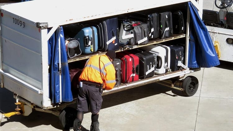 Bagagiste organisant des sacs à l'aéroport pour le vol.