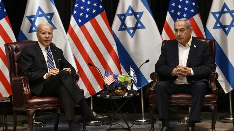 Biden et Netanyahu discutent avec drapeaux d'Israël et des États-Unis en arrière-plan.
