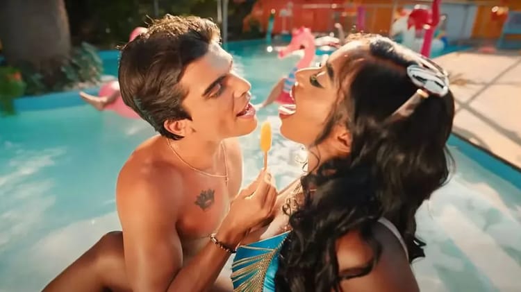 Jeune femme et homme partageant une glace près de la piscine ensoleillée.