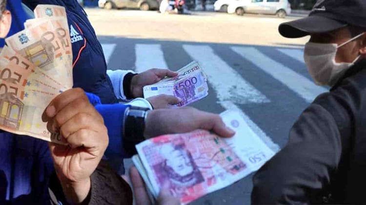 Personne échangeant des euros contre des dinars algériens dans la rue.
