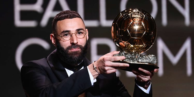 Karim Benzema tenant le Ballon d'Or lors d'une cérémonie.