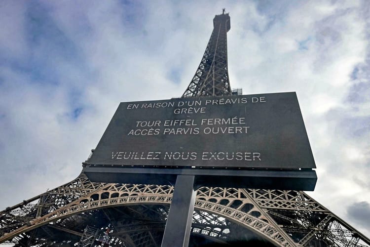 Tour Eiffel fermée avec panneau de protestation en France.