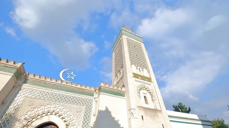 Mosquée tunisienne avec minaret sous ciel bleu clair.