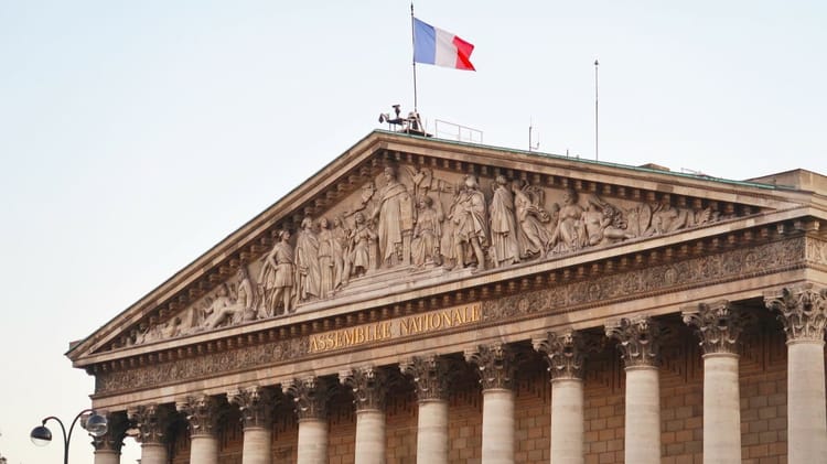 Façade de l'Assemblée Nationale avec drapeau français.