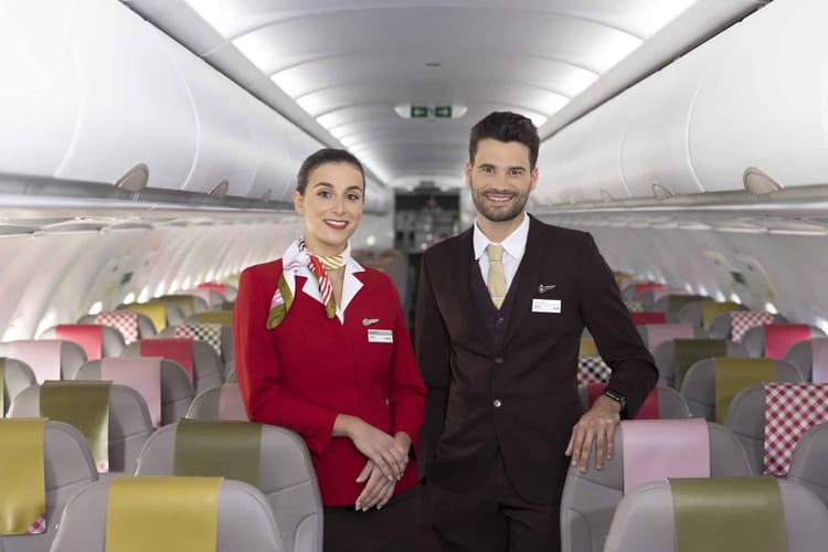 Deux agents de cabine Volotea dans l'avion, souriants et professionnels.