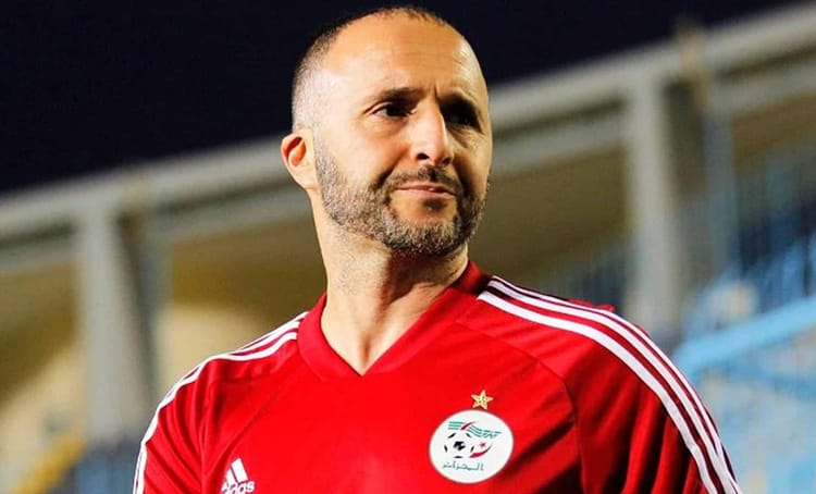 Djamel Belmadi : Quelle destination après l'Algérie ? Les rumeurs dévoilées Djamel Belmadi, entraîneur de football algérien, en tenue rouge sur le terrain.