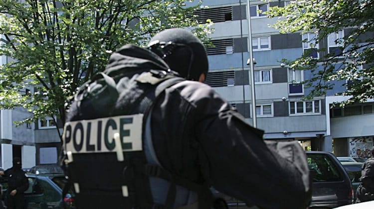 Tragédie familiale à Drancy : une mère de famille Kabyle victime d'un acte impensable Policier en uniforme avec le mot 'POLICE' visible dans un quartier résidentiel.