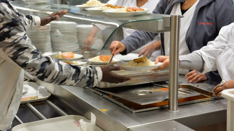 ONDULATION DIGITALE: L'ONSU révolutionne l'éducation Algérienne avec une plateforme numérique inédite! Personnel servant des plats dans une cuisine collective moderne.