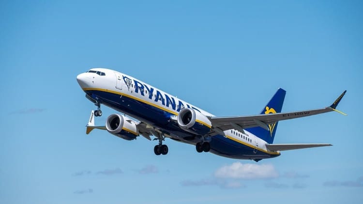 Avion Ryanair en vol dans un ciel bleu clair.