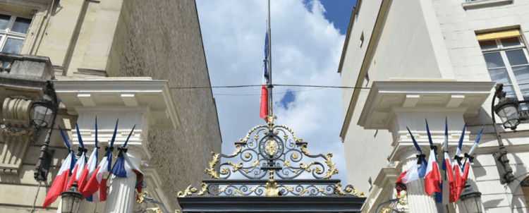 Porte d'entrée du centre de rétention avec drapeaux français.
