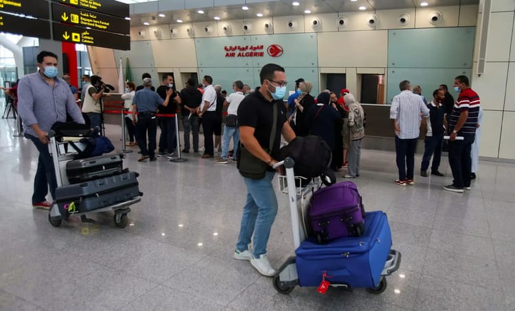 Aéroport d’Alger : de nouvelles mesures sophistiquées annoncées, pour renforcer la sécurité des passagers Passagers à l'aéroport d'Alger avec bagages, portant des masques.