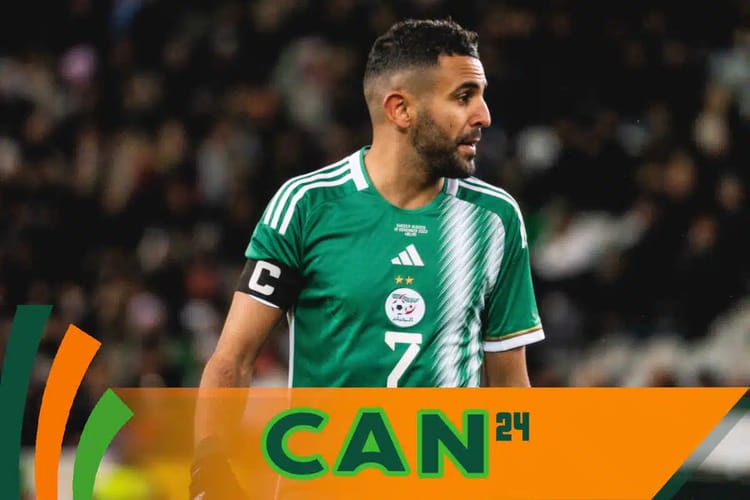 Joueur de football algérien portant maillot vert lors d'un match.