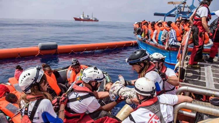 Migrants disparus en Mer 2023 : Record historique et crise humanitaire Migrants en mer avec équipes de secours, crise humanitaire en cours.