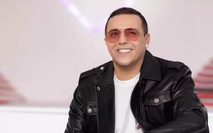 Dédicace de « Chokran » à Mohammed VI : Faudel répond aux critiques Faudel souriant portant des lunettes roses et une veste en cuir noir.