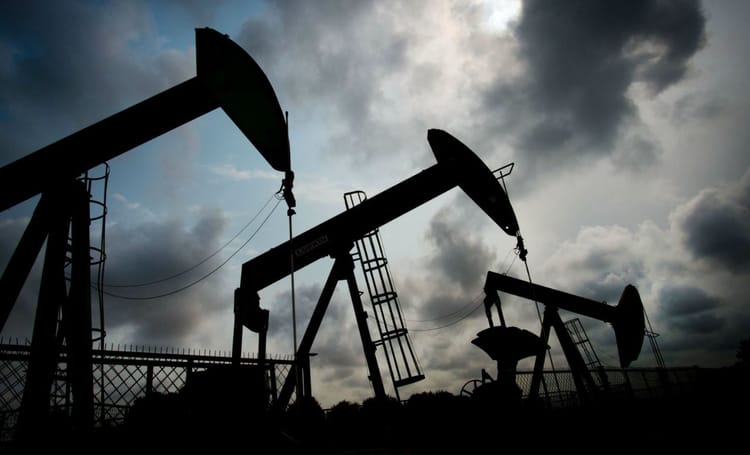 Impact contrasté de la baisse des cours du pétrole en Afrique : Gagnants et Perdants Pompes à pétrole en silhouette sous ciel nuageux en Afrique.