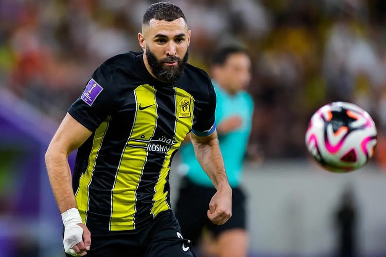 Karim Benzema en maillot noir et jaune, prêt à jouer au football.