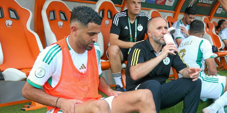 Joueur algérien sur le banc pendant un match de football.