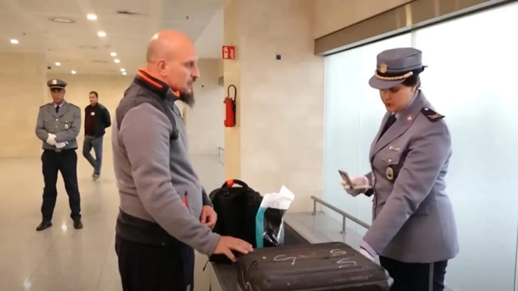 Agent de sécurité vérifiant un passager avec téléphone à l'aéroport.