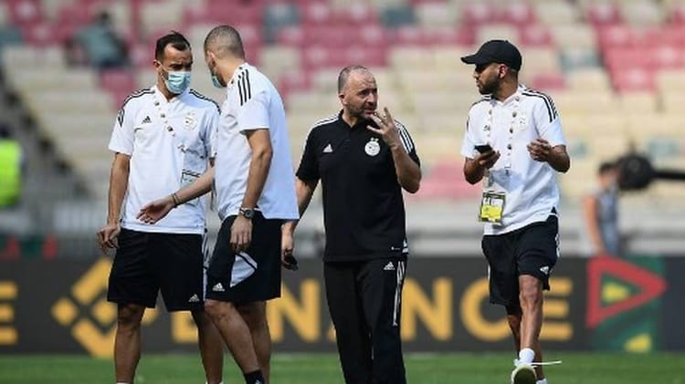 Les entraîneurs et joueurs algériens discutent lors d'un match.