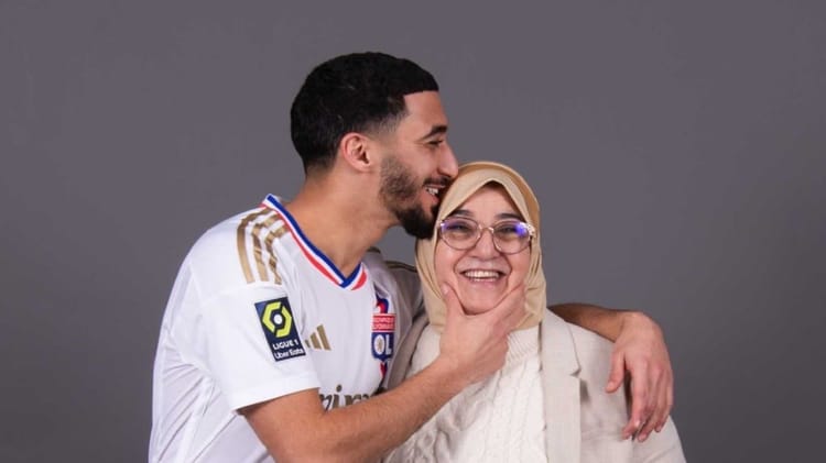 Saïd Benrahma accueillie par l'OL : Tout pour la mama... Saïd Benrahma souriant avec une femme lors d'un événement sportif.