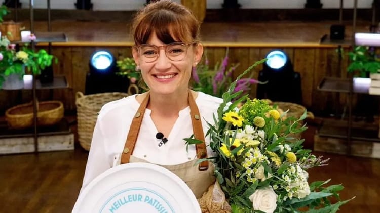 Une pâtissière algérienne championne avec un bouquet de fleurs.
