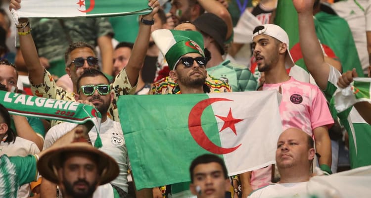 Supporters algériens avec drapeau lors d'une manifestation.
