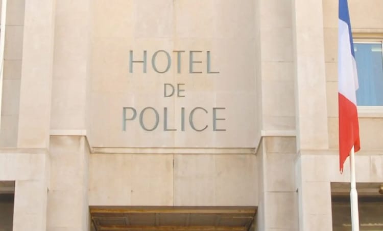 Façade de l'hôtel de police avec drapeau français.