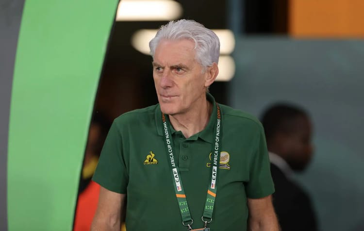 Entraîneur en polo vert avec badge lors d'un match de football.