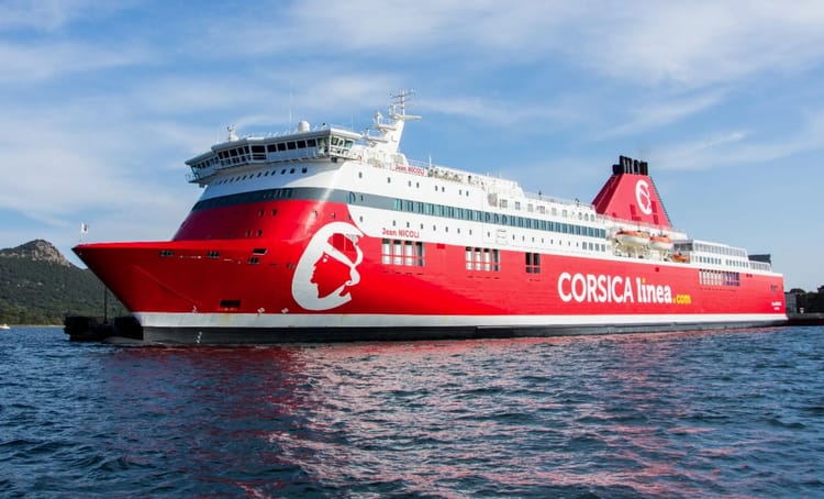 Ferry Corsica Linea rouge en mer avec ciel bleu clair.