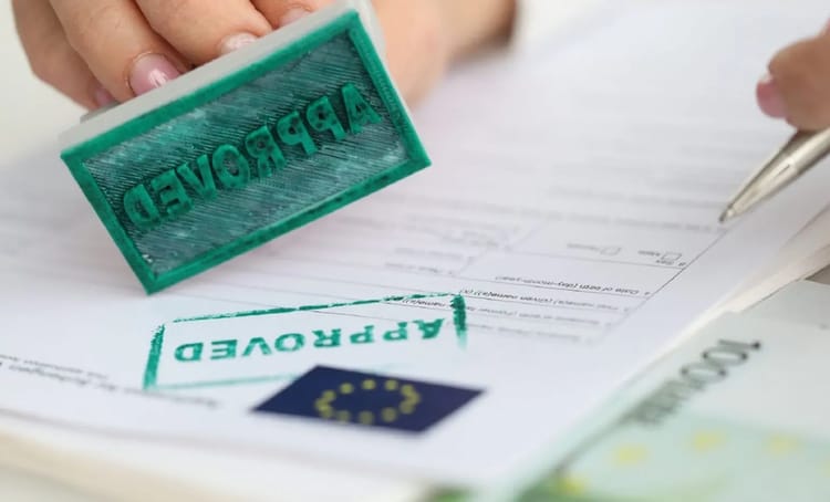 Europe/Travail sans permis d'exercer : vous risquez ceci... Signature d'un document avec un tampon "approuvé" et un stylo.
