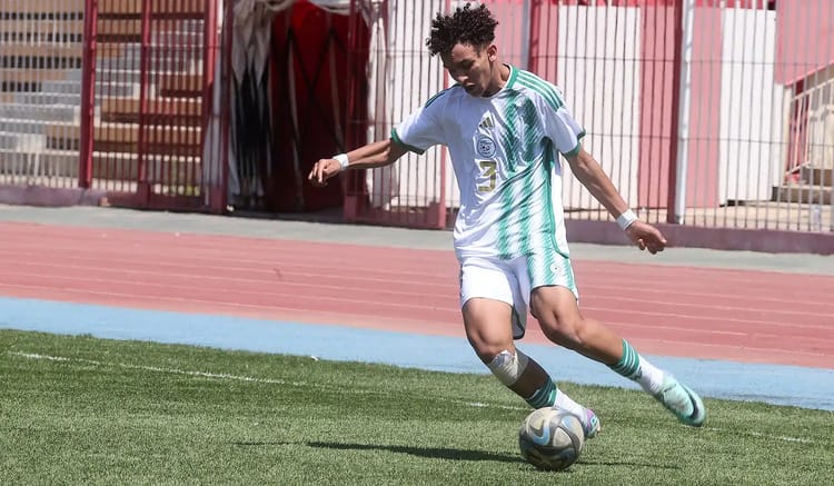 Jeune joueur algérien dribblant le ballon lors d'un match.