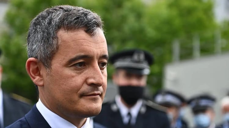 Gérald Darmanin en discussion avec des policiers en extérieur.