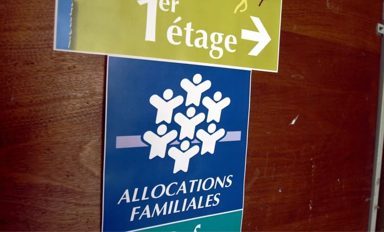 Panneaux indiquant l'orientation vers les allocations familiales et le premier étage.