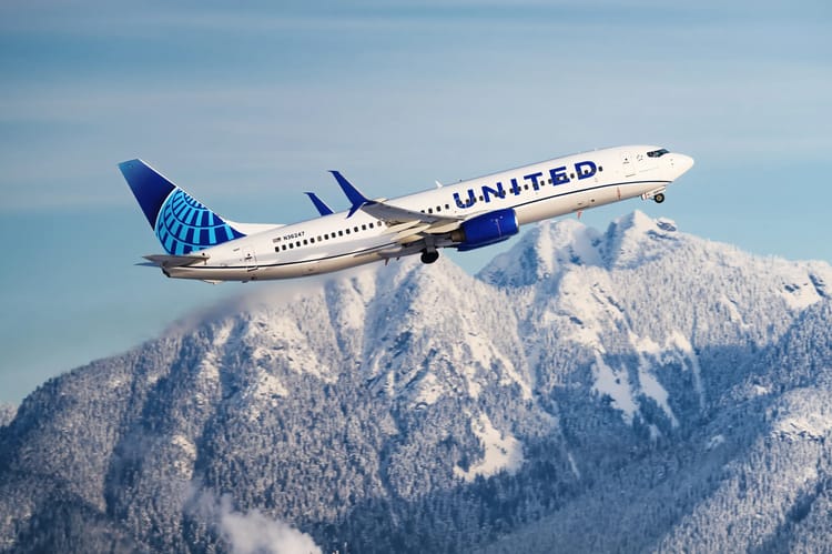 Avion United Airlines survole des montagnes enneigées.