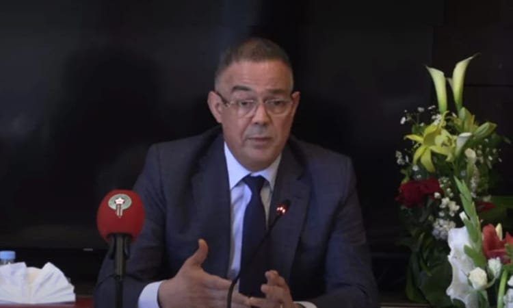 Fouzi Lekjaa est mis Ko : Un coup fatal, qui enterre définitivement ses rêves de... Fouzi Lekjaa en réunion, parlant devant microphone et fleurs.