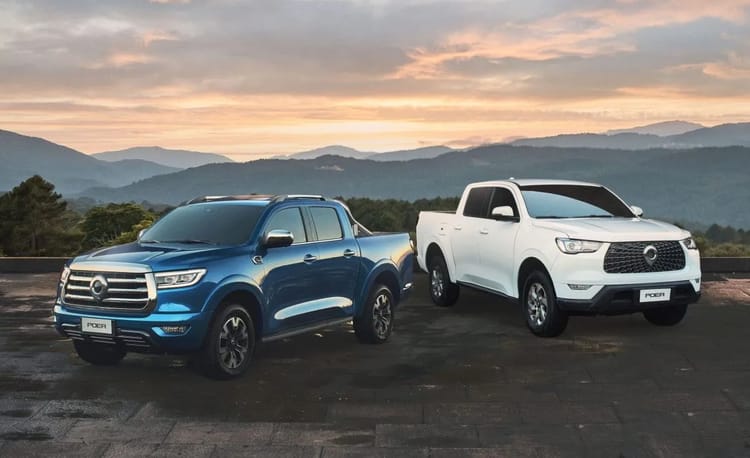 Deux pick-up Great Wall en plein air avec paysage montagneux au coucher du soleil.