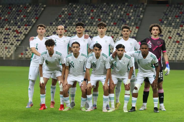 Groupe de joueurs de football en uniforme blanc sur le terrain.