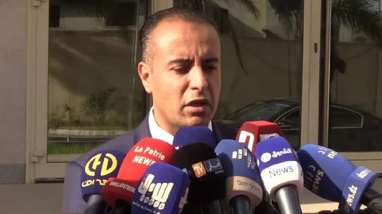 Walid Sadi parlant à la presse avec plusieurs microphones.