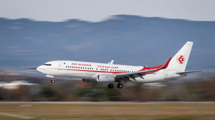 Avion Air Algérie en vol au-dessus du paysage.