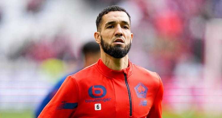 Nabil Bentaleb lors d'un match de football, concentré sur le jeu.