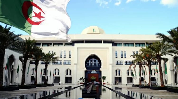 Algérie : les binationaux de moins de 12 ans peuvent rentrer au bercail avec seulement ces deux documents... Bâtiment gouvernemental en Algérie avec drapeau national algérien.