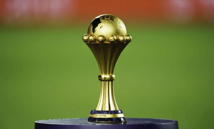 Trophée doré de la CAN 2025 sur fond vert.